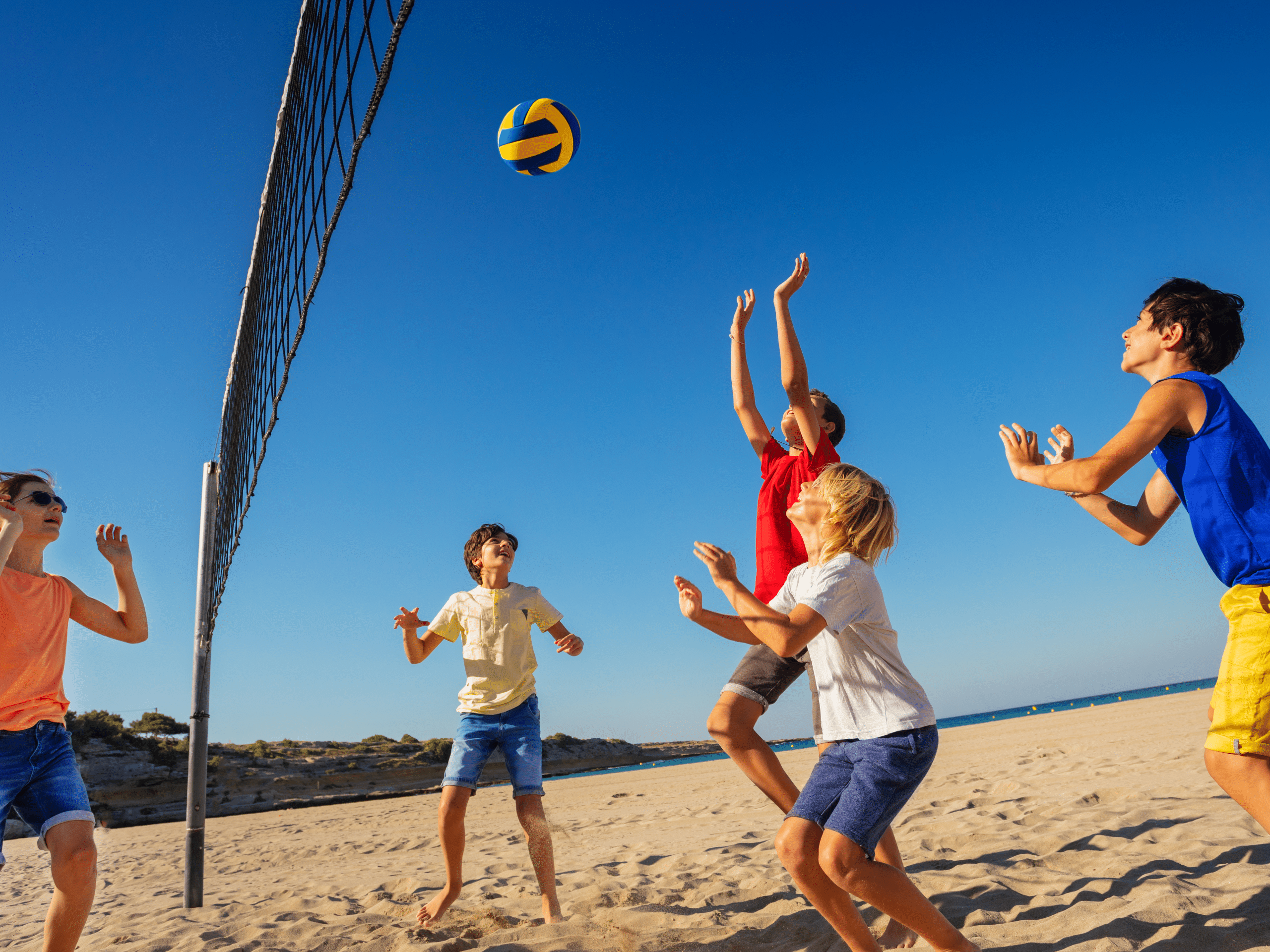 children playing volleyball at the beach