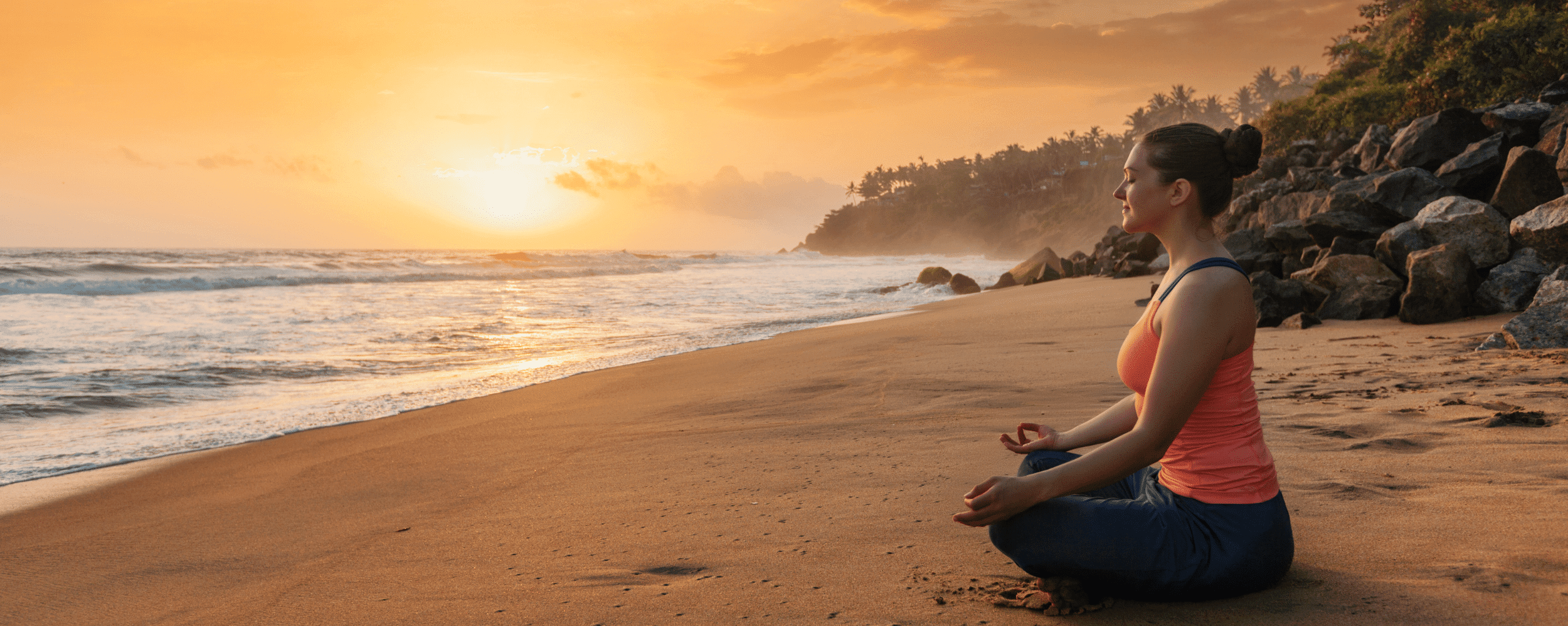 a woman practicing meditation on the beach