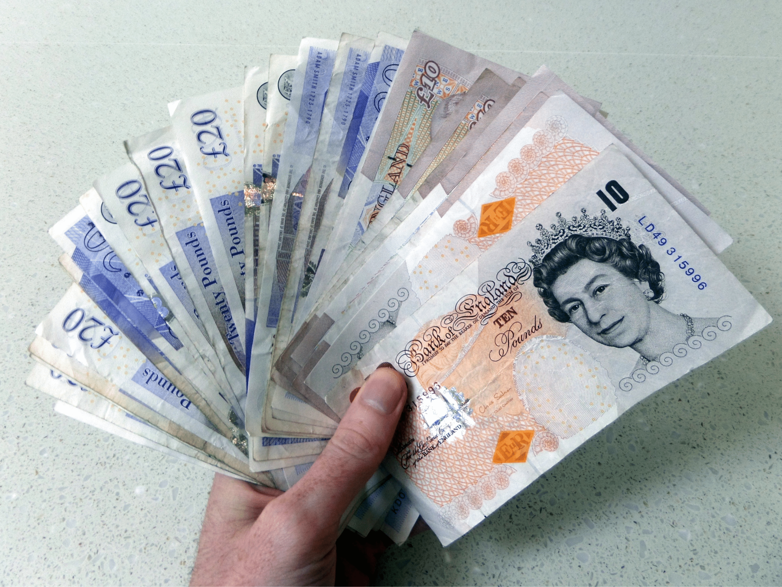 a woman's hand holding northumberland currency British pound sterling