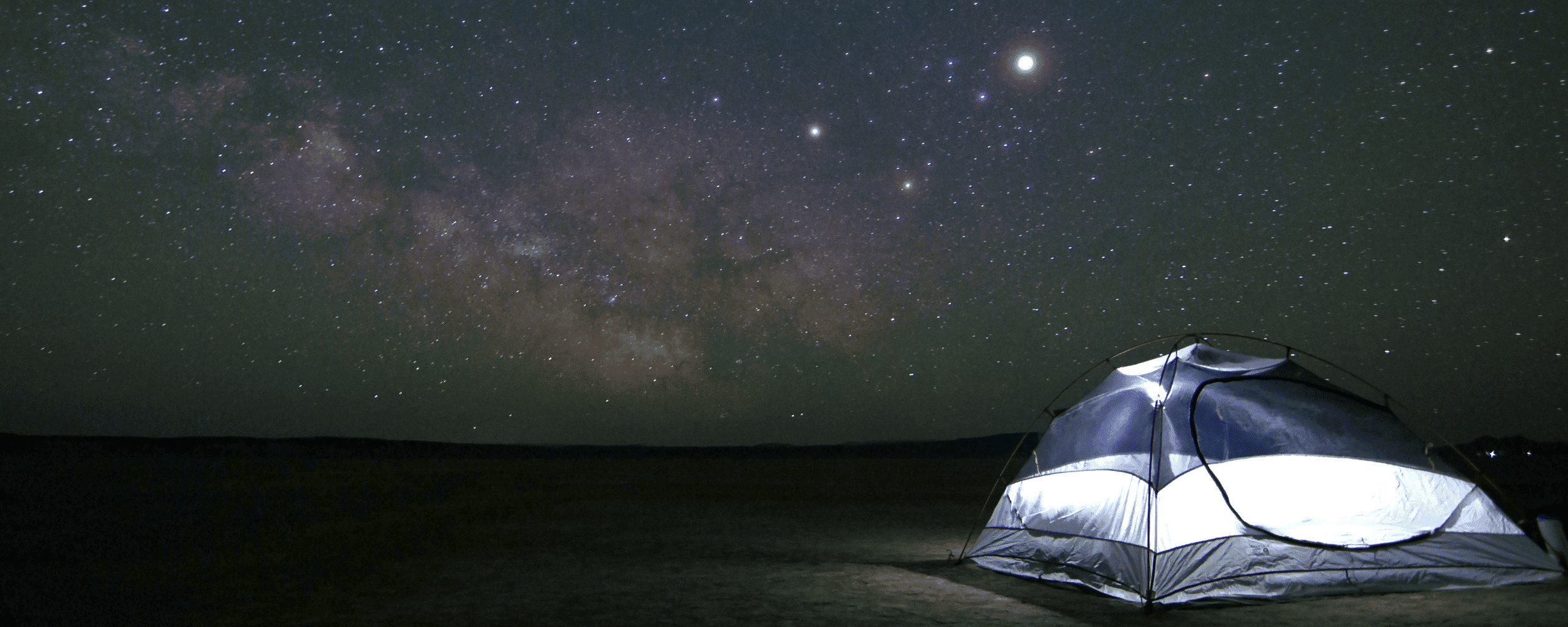 the starry sky and a camping tent by the beach
