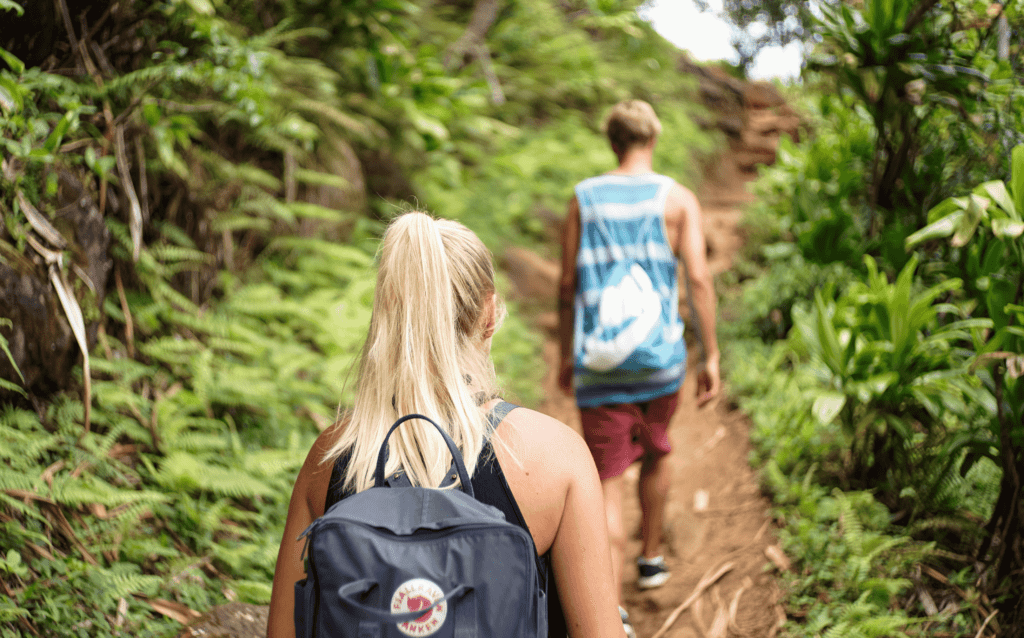 a man and woman hiking at pu uka oku falls