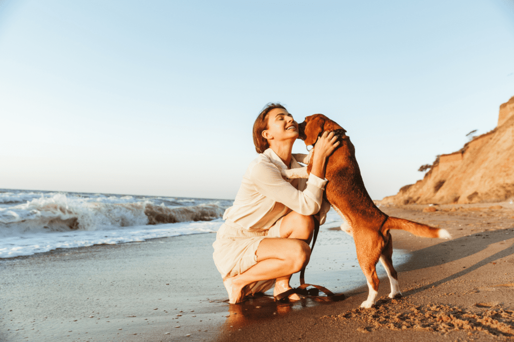 a woman hugging her brown colored dog at krull park dog beach