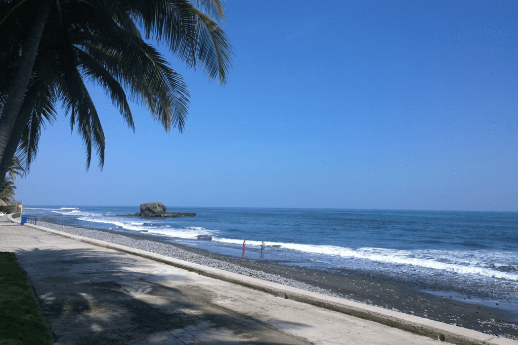 a sunny day at la libertad beach. two people watching the beach waves in el salvador beaches.